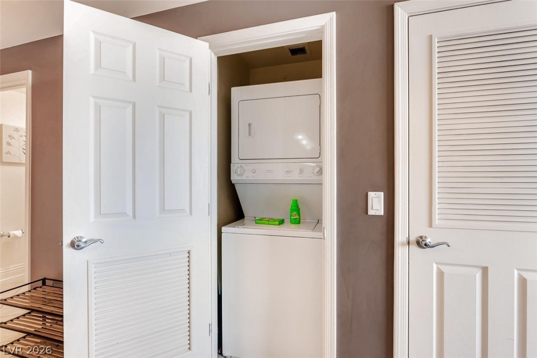 210 East Flamingo Road, Unit 137 Las Vegas, NV 89169 - Photo 21 of 32 A compact laundry space includes a stacked washer and dryer, thoughtfully placed behind louvered doors.
