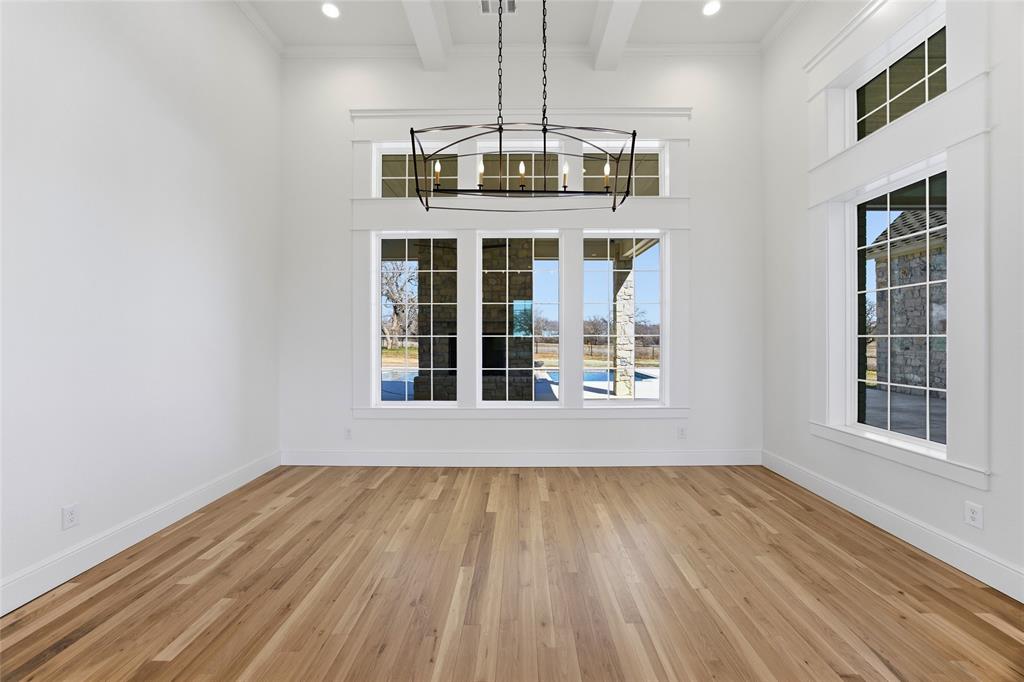 623 Lake Valley Road Sunset, TX 76270 - Photo 14 of 40 a view of an empty room with wooden floor and a window