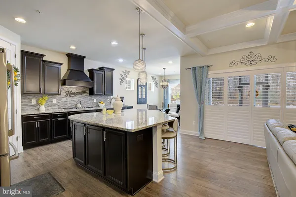 a kitchen with kitchen island granite countertop a sink appliances and cabinets