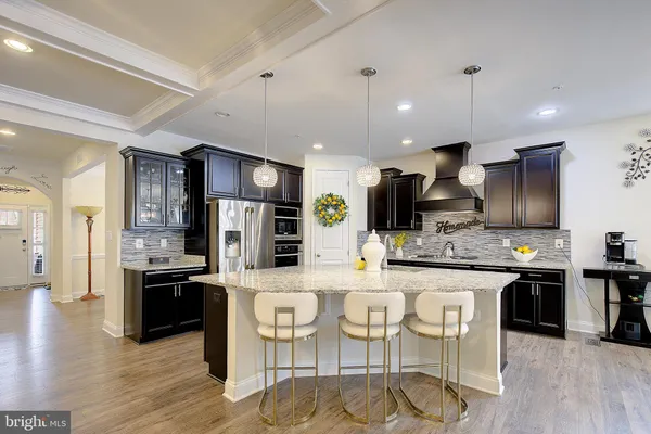 a kitchen with stainless steel appliances kitchen island granite countertop a stove refrigerator and cabinets