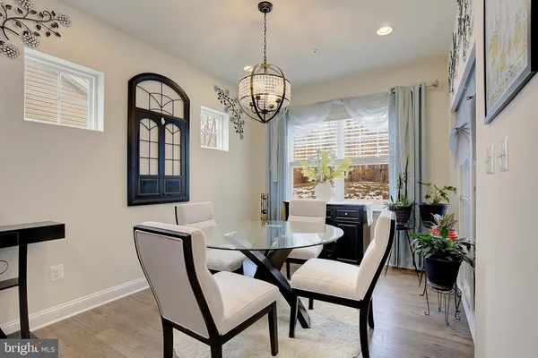 a dining room with furniture a chandelier and wooden floor