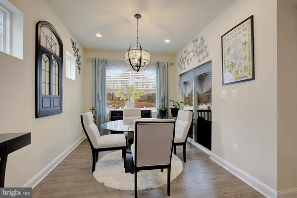 a dining room with furniture a chandelier and wooden floor