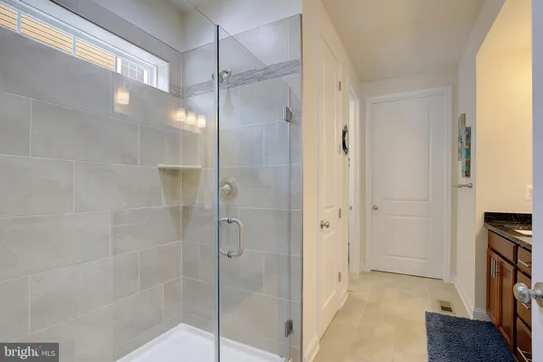 a bathroom with a granite countertop double vanity sink and a mirror