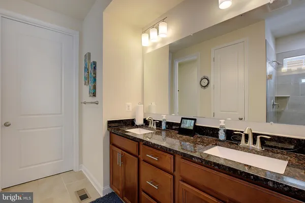 a en suite bathroom with a double vanity sink and a mirror