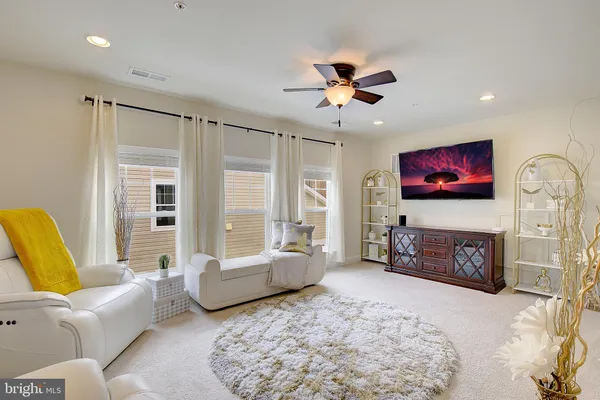 a spacious bedroom with a bed a couch and a chandelier