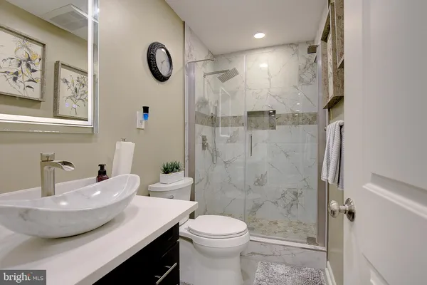 a living room with stainless steel appliances furniture and a flat screen tv