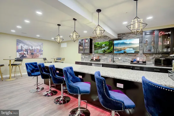 a kitchen with stainless steel appliances kitchen island granite countertop a sink dishwasher a dining table and chairs with wooden floor