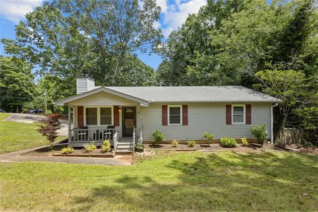 a front view of house with yard and trees in the background