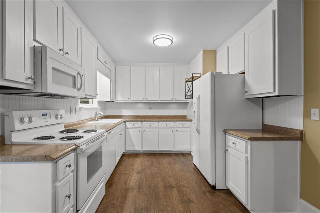 8990 Tweeddale Drive Winston, GA 30187 - Photo 11 of 26 a kitchen with granite countertop a refrigerator stove top oven and cabinets
