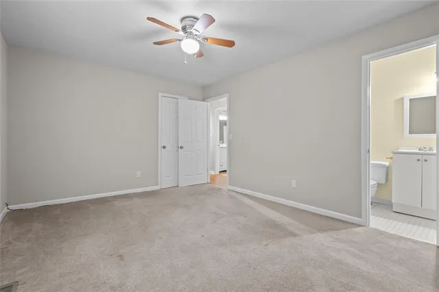 an empty room with closet and a chandelier fan