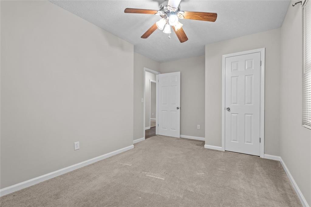 8990 Tweeddale Drive Winston, GA 30187 - Photo 20 of 26 an empty room with closet and a chandelier fan