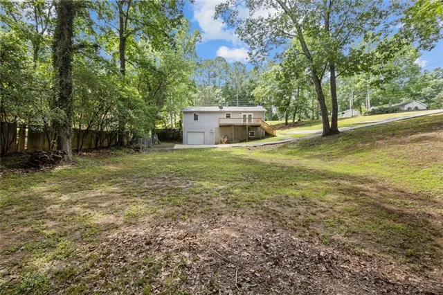 a view of an empty room with wooden floor fireplace and a window