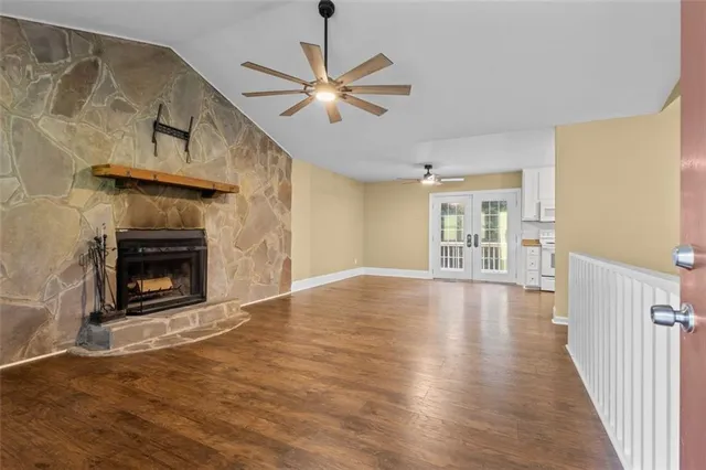a kitchen with stainless steel appliances granite countertop a stove a sink and white cabinets with wooden floor
