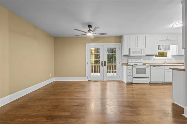 a kitchen with granite countertop white cabinets and white appliances