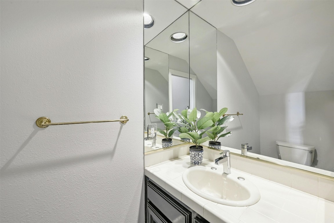 1937 Rue De St Tropez, Unit 9 Austin, TX 78746 - Photo 17 of 33 a bathroom with a sink and a mirror