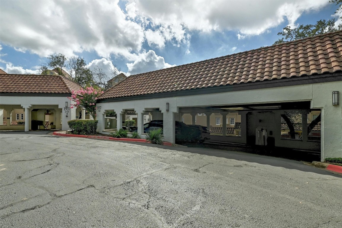 1937 Rue De St Tropez, Unit 9 Austin, TX 78746 - Photo 24 of 33 a front view of a house with a garage
