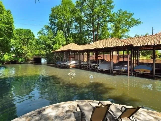 a view of a swimming pool with lawn chairs under an umbrella