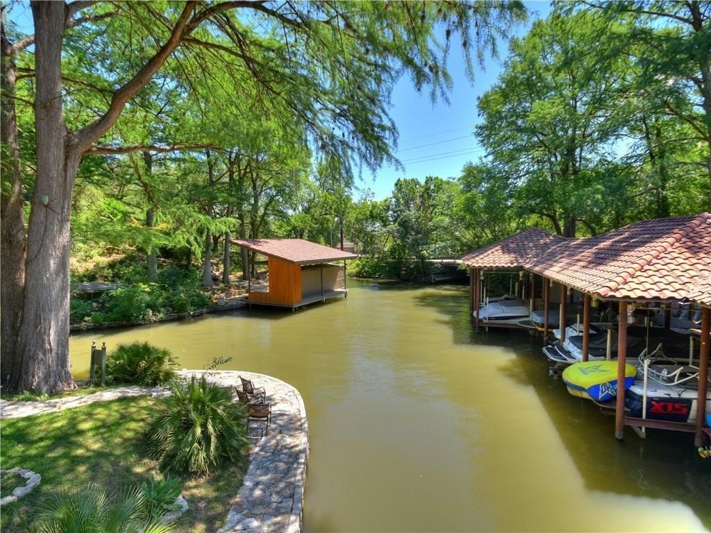 1937 Rue De St Tropez, Unit 9 Austin, TX 78746 - Photo 33 of 33 a view of a swimming pool with lawn chairs under an umbrella