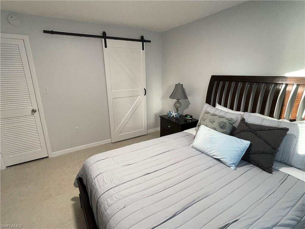 170 Turtle Lake Court, Unit 103 Naples, FL 34105 - Photo 12 of 37 a bedroom with a bed and a couch
