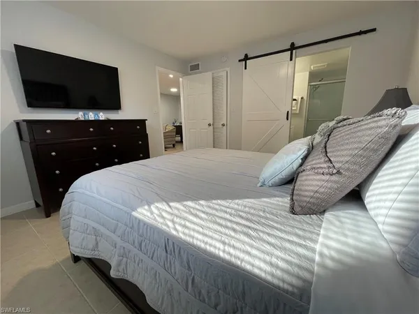 a bedroom with a bed and a flat screen tv