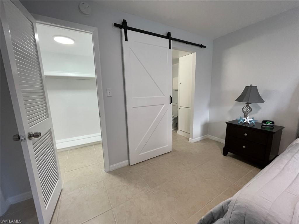 170 Turtle Lake Court, Unit 103 Naples, FL 34105 - Photo 16 of 37 a room with a bed and a shower