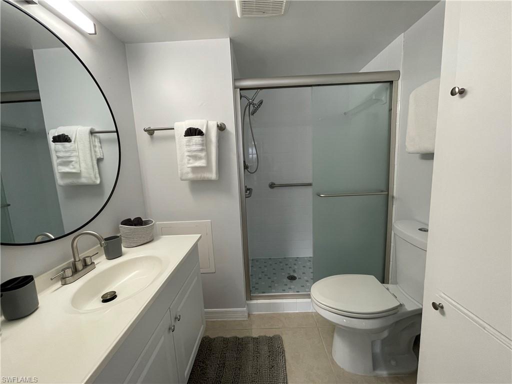 170 Turtle Lake Court, Unit 103 Naples, FL 34105 - Photo 17 of 37 a bathroom with a sink a toilet and a mirror