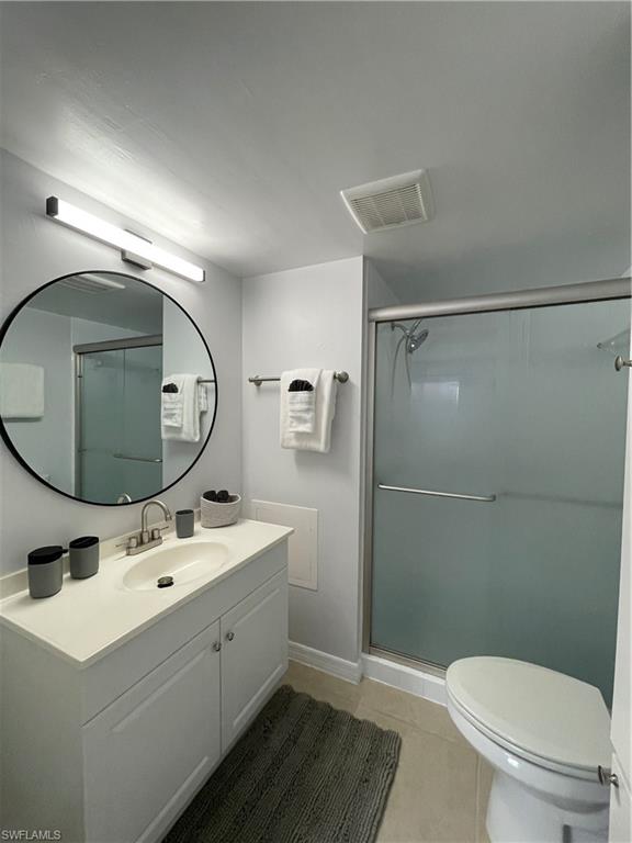 170 Turtle Lake Court, Unit 103 Naples, FL 34105 - Photo 18 of 37 a bathroom with a toilet a sink and mirror