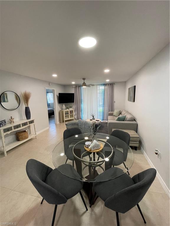 170 Turtle Lake Court, Unit 103 Naples, FL 34105 - Photo 2 of 37 a living room with furniture a table and chairs