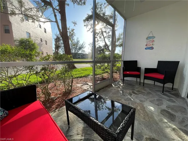 a view of a street sign under a large tree