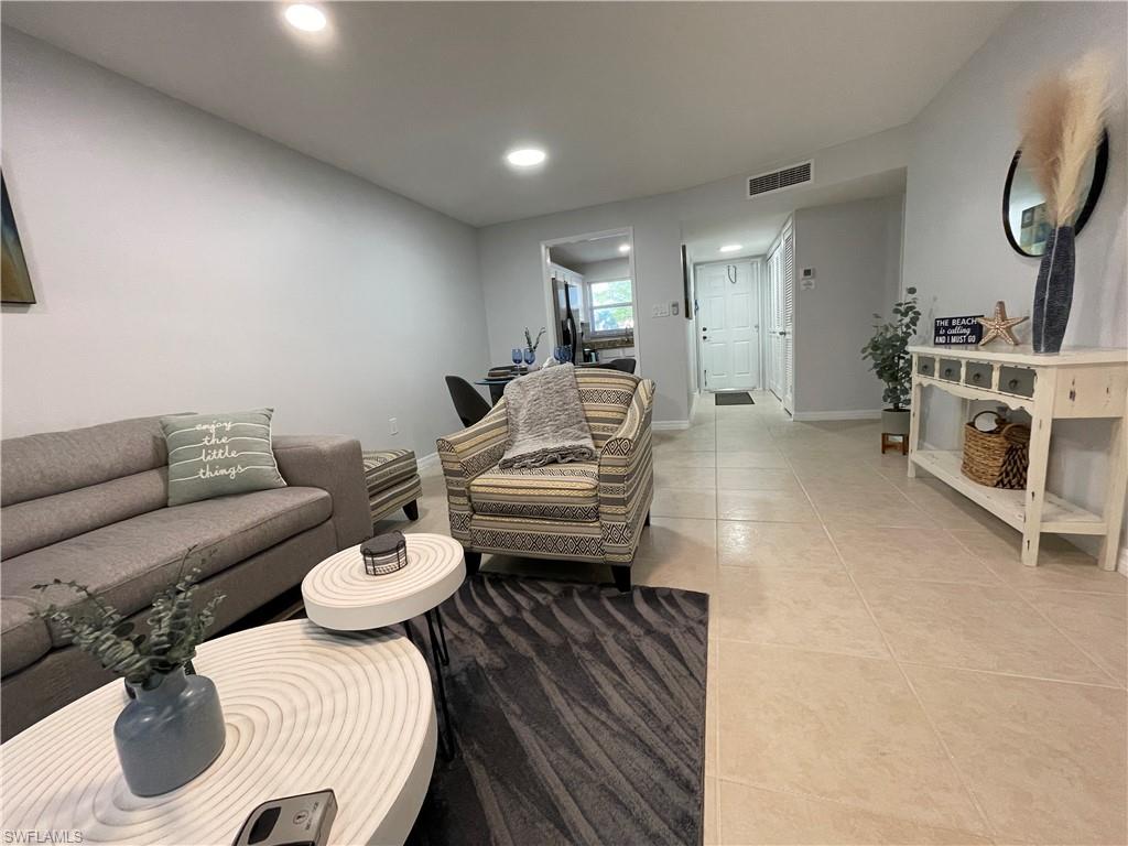 170 Turtle Lake Court, Unit 103 Naples, FL 34105 - Photo 7 of 37 a living room with furniture and a wooden floor