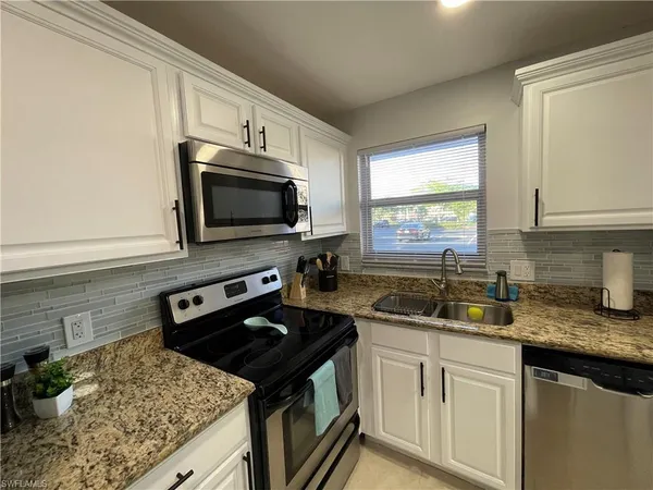 a kitchen with a sink stove and microwave