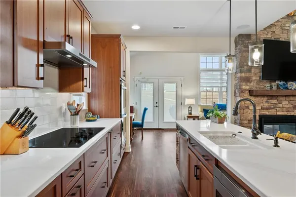 a kitchen with a sink stove and wooden floor