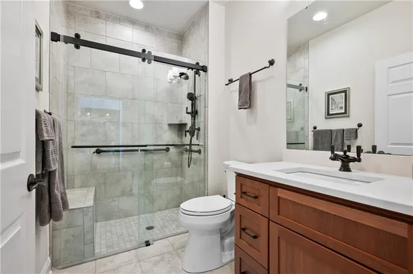 a bathroom with a sink toilet a mirror and shower