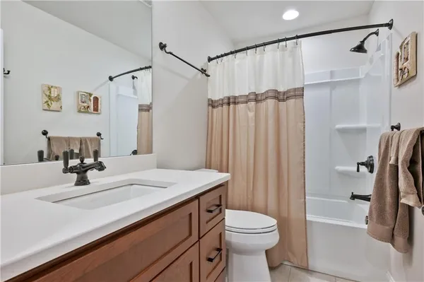 a bathroom with a sink a toilet a mirror and shower