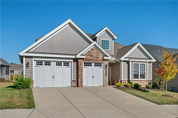 a view of a house with a yard and large tree
