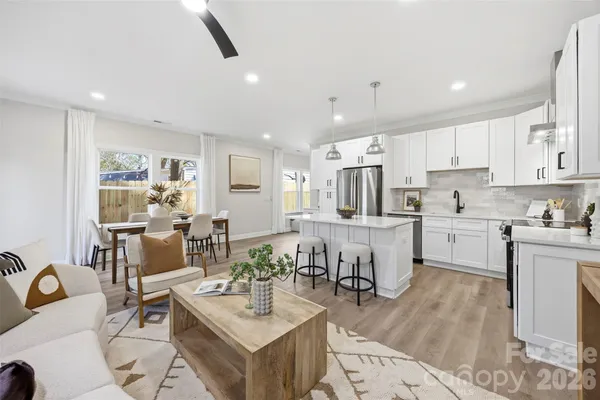 a kitchen with a sink stove and white cabinets with wooden floor