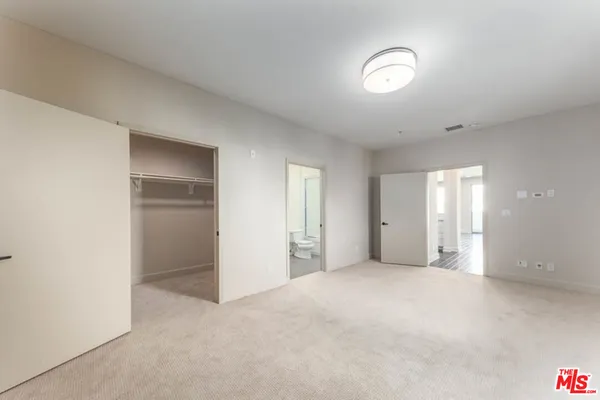 an empty room with windows and closet