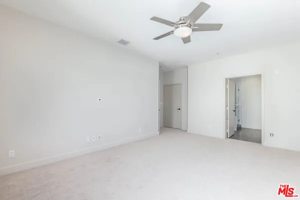 an empty room with a ceiling fan and a window