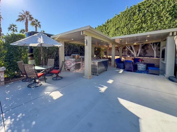 a view of a patio with table and chairs under an umbrella