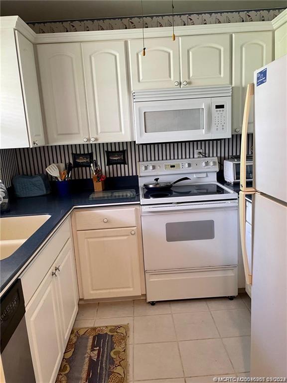 2600 Southeast Ocean Boulevard, Unit H9 Stuart, FL 34996 - Photo 3 of 21 a kitchen with white cabinets and white appliances