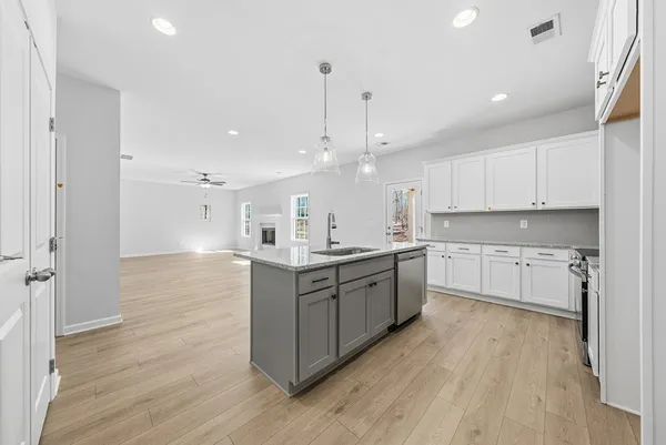 a kitchen with stainless steel appliances sink cabinets and wooden floor