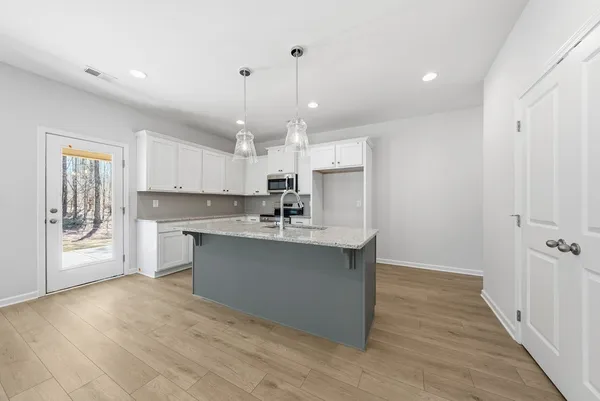 a kitchen with kitchen island a sink stainless steel appliances and cabinets