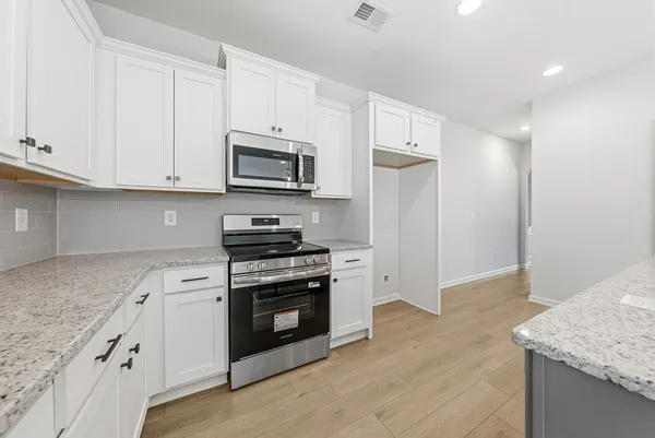 a kitchen with stainless steel appliances granite countertop a stove a refrigerator and a microwave