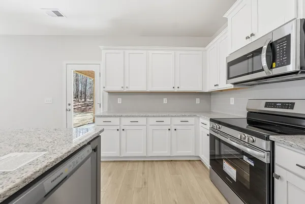 a kitchen with granite countertop cabinets stainless steel appliances and a sink