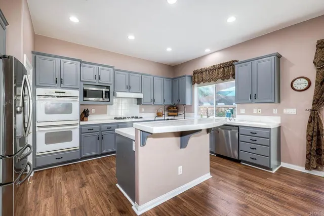 a kitchen with kitchen island granite countertop a sink stove and refrigerator