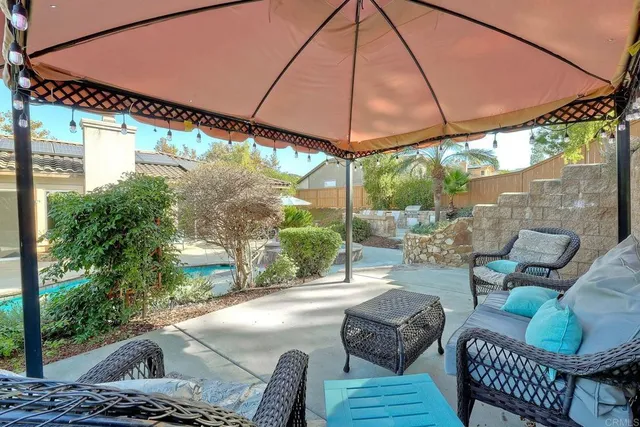 a view of a swimming pool with a table and chairs under an umbrella