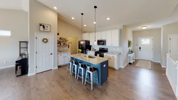 a kitchen with stainless steel appliances kitchen island granite countertop a refrigerator and a stove top oven