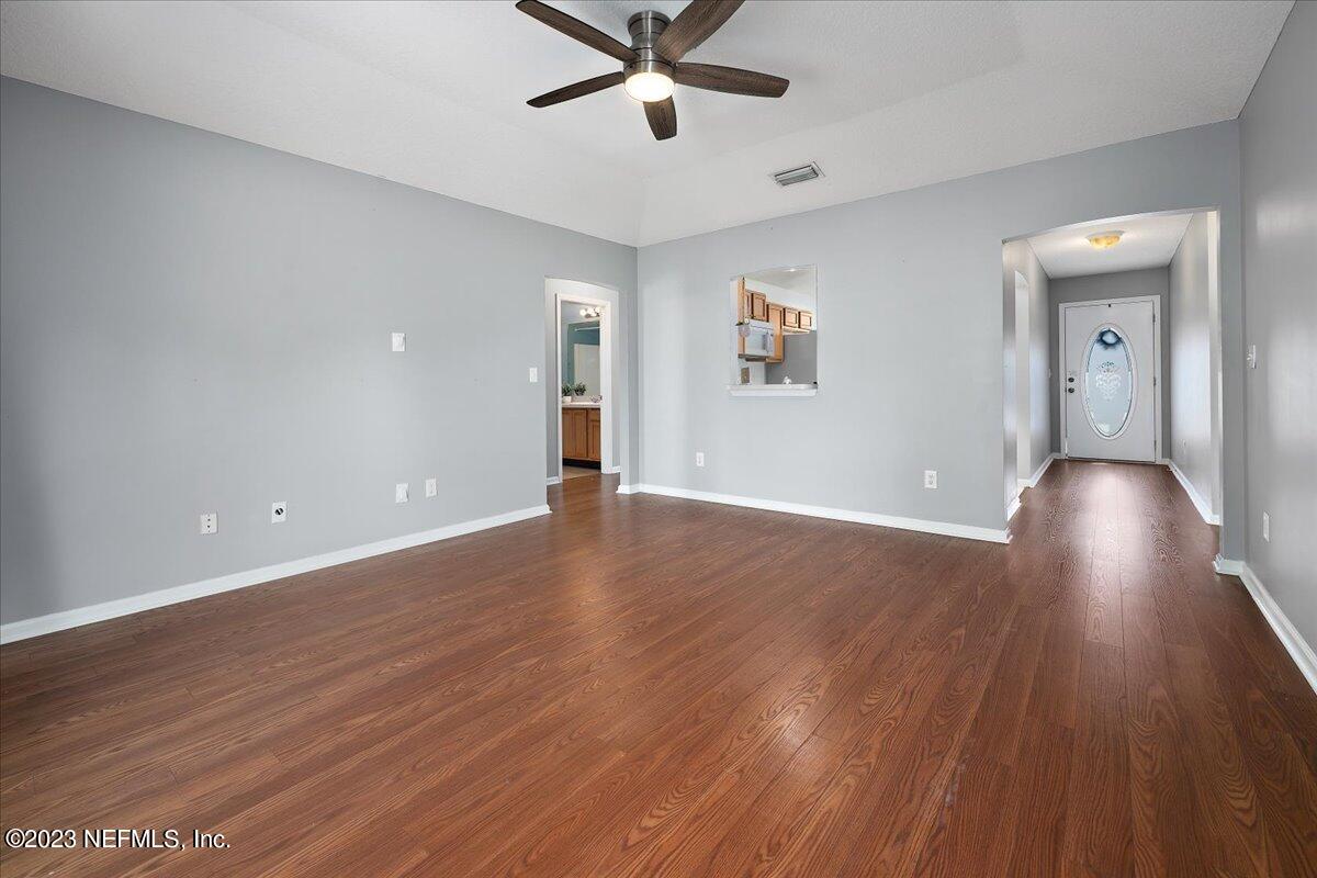 681 Fox Run Circle Macclenny, FL 32063 - Photo 4 of 18 wooden floor in an empty room with a window