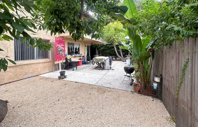 a view of backyard with table and chairs and a large tree