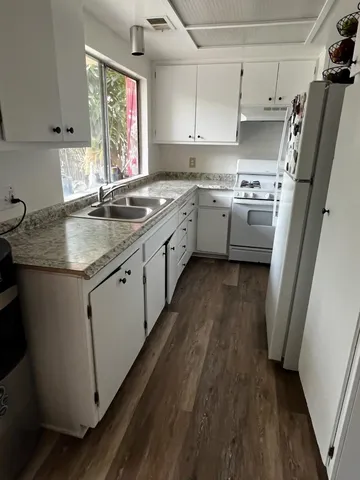 a kitchen with stainless steel appliances granite countertop a sink a stove a refrigerator and cabinets